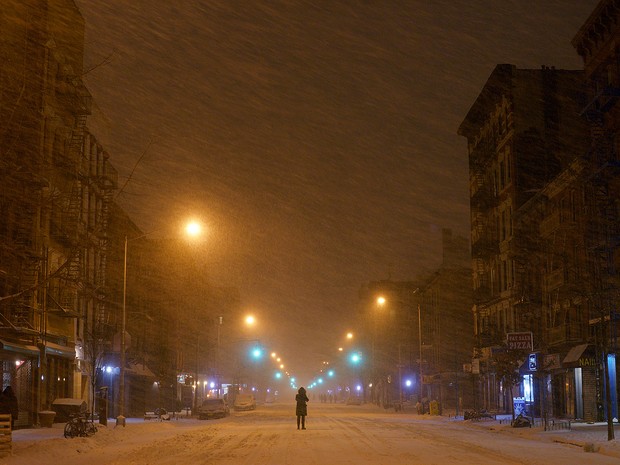 Pessoa caminha no meio da nevasca na Avenida A em East Village na região de Nova York durante a madrugada desta terça-feira (27) (Foto: Patrick Sison/AP Photo)