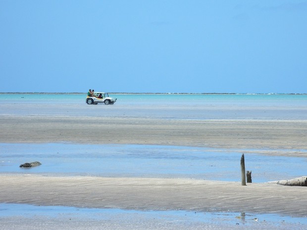 Buggy com turistas percorre tercho dentro de área de mar (Foto: Waldson Costa/G1)