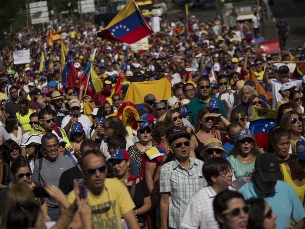 Manifestantes com bandeiras da Venezuela durante protesto contra o presidente Nicolás Maduro, na Espanha (Foto: AP Photo/Francisco Seco)