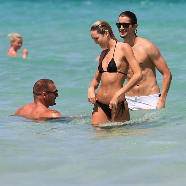 Candice dá uma ajeiadinha no biquíni ao sair do mar (Foto: Splashnews)