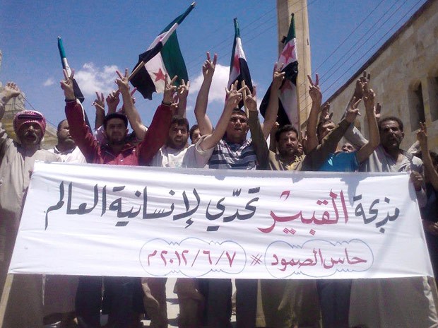 Manifestantes protestam nesta quinta-feira (7) em Hass, na província síria de Idlib, contra o massacre da véspera (Foto: AP)