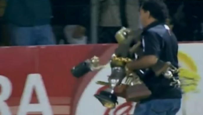 Funcionário recolhe troféus do Guaraní (Foto: Reprodução SporTV) Funcionário recolhe troféus do Guaraní (Foto: Reprodução SporTV)