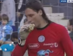 Juan Carlos Olave, do Belgrano, come hambúrger atirado pela torcida do Racing