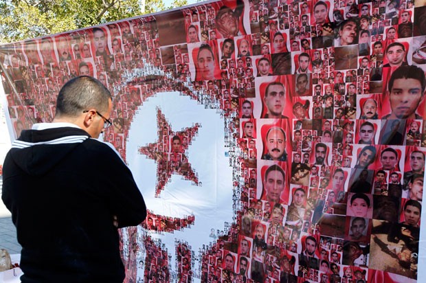 Homem observa homenagem durante a celebração do segundo aniversário da revolução tunisiana em foto de janeiro de 2013 (Foto: Anis Mili/Reuters)