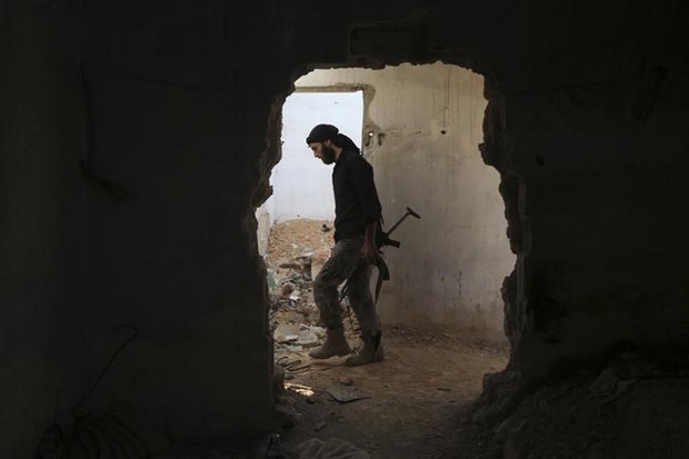 Homem armado anda em prédio abandonado em Damasco, na Síria (Foto: Bassam Khabieh/ Reuters)