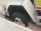 Caminhão fica com roda entalada em buraco no asfalto em Bauru