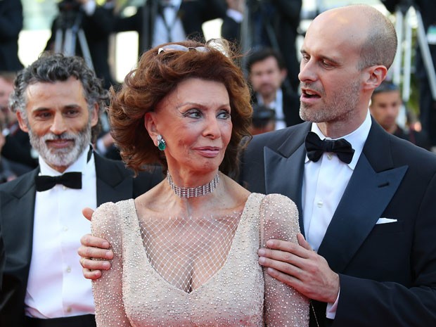 A atriz italiana Sophia Loren é abraçada pelo filho, o diretor Edoardo Ponti, no tapete vermelho do Festival de Cannes; à esquerda, o ator Enrico Lo Verso  (Foto: Loic Venance/AFP)