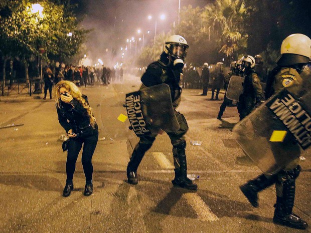 Uma manifestante reage após inalar gás lacrimogêneo durante confrontos com a polícia em uma marcha que marca o 41º aniversário de uma revolta estudantil de 1973 contra a ditadura militar, então no poder, em frente à embaixada dos EUA em Atenas, na Grécia (Foto: Yannis Behrakis/Reuters) Uma manifestante reage após inalar gás lacrimogêneo durante confrontos com a polícia em uma marcha que marca o 41º aniversário de uma revolta estudantil de 1973 contra a ditadura militar, então no poder, em frente à embaixada dos EUA em Atenas, na Grécia (Foto: Yannis Behrakis/Reuters)