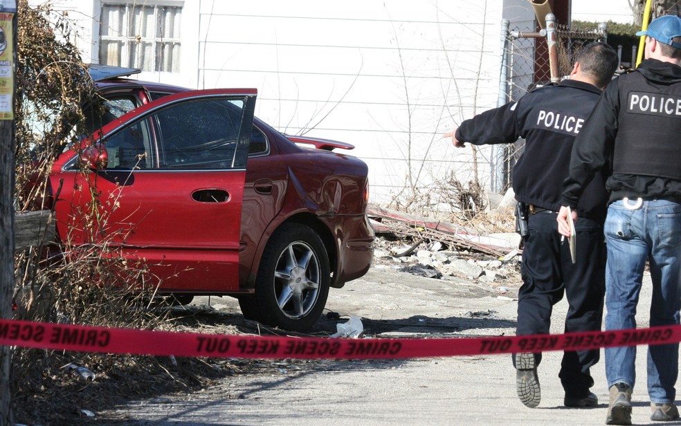 Policiais investigam local onde um menino e um homem foram baleados dentro de um carro em Chicago, um crime transmitido ao vivo pelo Facebook na terça-feira (14) (Foto: Eric Clark/Chicago Tribune via AP)