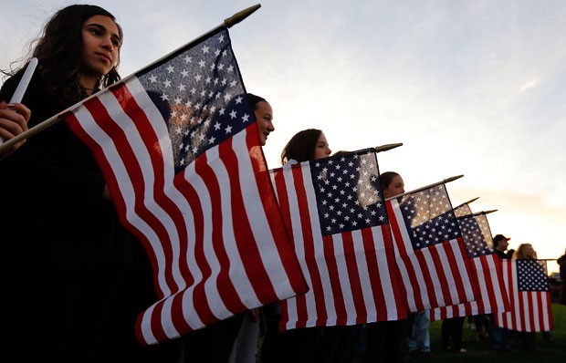 Em Watertown, bandeiras e velas são usadas em vigília pelas vítimas dos atentados na maratona de Boston (Foto: Jared Wickerham/Getty Images/AFP )