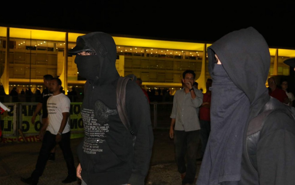 Dupla de manifestantes esconde rosto durante ato contra Michel Temer na Praça dos Três Poderes, em Brasília (Foto: Alvaro Costa/TV Globo)
