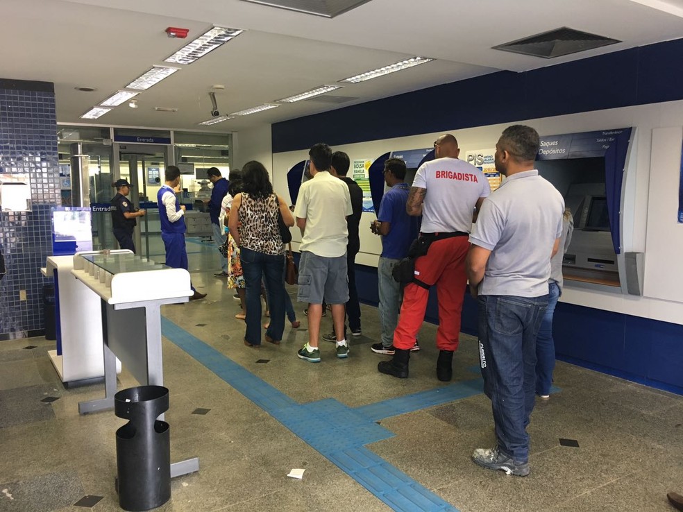 Grupo faz fila em agência da Caixa para sacar FGTS (Foto: Luiza Garonce/G1)