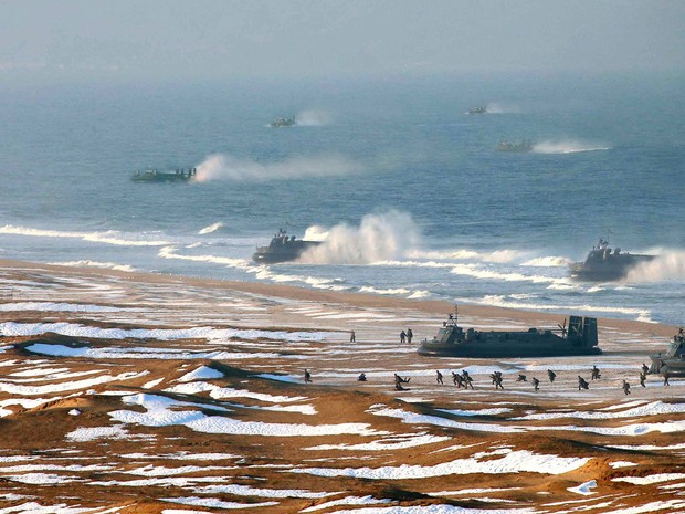 Tropas norte-coreanas fazem treinamento de chegada e defesa de costa em praia não identificada do país. Em meio ao momento de tensão internacional, o país colocou suas tropas em posição de combate, com armas apontadas para alvos americanos. (Foto: AFP/KCNA)