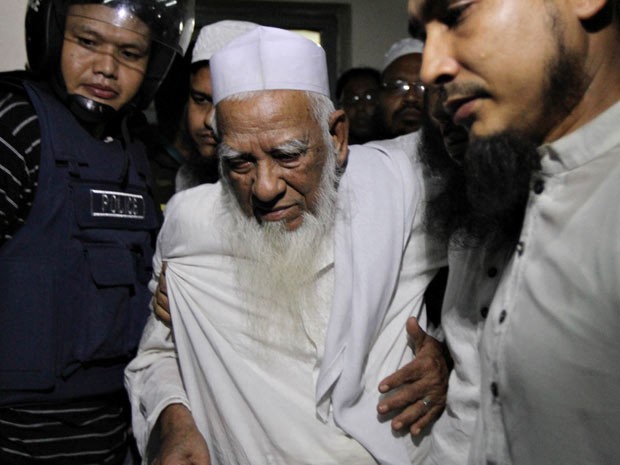 Allama Shah Ahmad Shahi é escoltado para fora de Daccar (Foto: AFP)