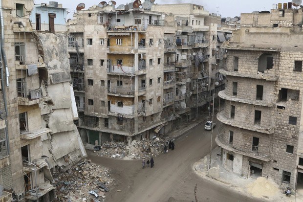  Pessoas caminham em bairro da cidade síria de Aleppo em 10/12 (Foto: Reuters/Mahmoud Hebbo)