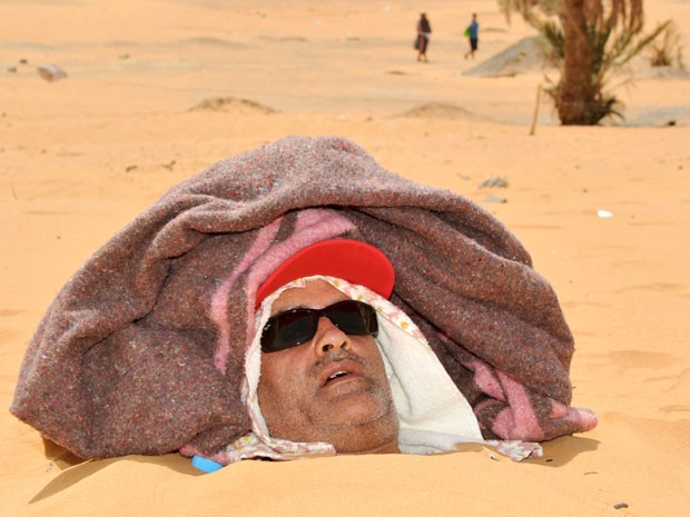 Turista é coberto de areia até o pescoço nas dunas de Merzouga (Foto: STR/AFP)
