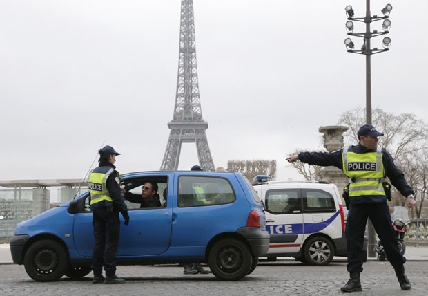 Policiais controlam a passagem de carros em Paris nesta segunda-feira (17); poluição levou governo a estabelecer rodízio de carros (Foto: Francois Guillot/AFP)