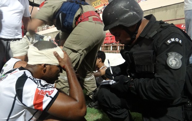 Policial recolhe nome de torcedor envolvido em briga (Foto: Caio Lorena / Globoesporte.com)