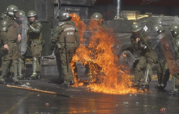 Bomba caseira lançada por manifestantes acertam policiais (Foto: Luis Hidalgo/AP)