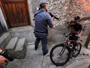 Policial fiscaliza morador durante operação na favela de Paraisópolis, na zona sul de São Paulo. (Foto: Nacho Doce/Reuters)