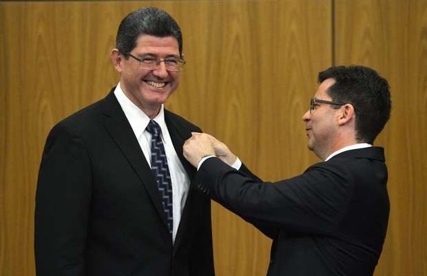 O novo ministro da Fazenda, Joaquim Levy (esquerda), recebe o cargo do ministro interino da Fazenda, Paulo Caffarelli (direita), em cerimônia no auditório do Banco Central. (Foto: Agência Brasil)