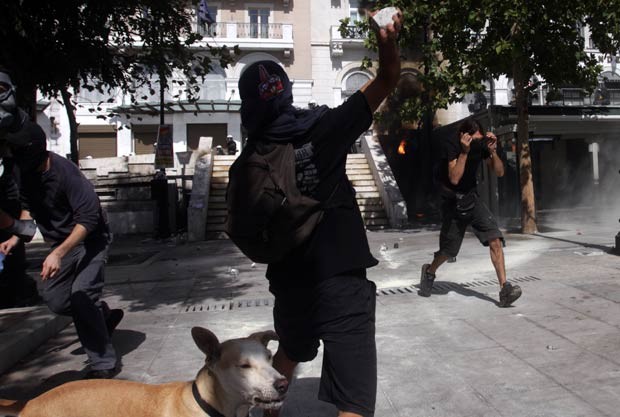 Manifestantes enfrentam a polícia durante protestos nesta quinta-feira (18) em Atenas (Foto: AFP)
