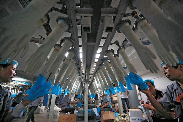 DRAGÃO RESISTENTE   Linha de produção de luvas em uma fábrica na China. O país  é o único membro dos Brics com uma boa perspectiva de crescimento em 2013 (Foto: Aly Song/Reuters)