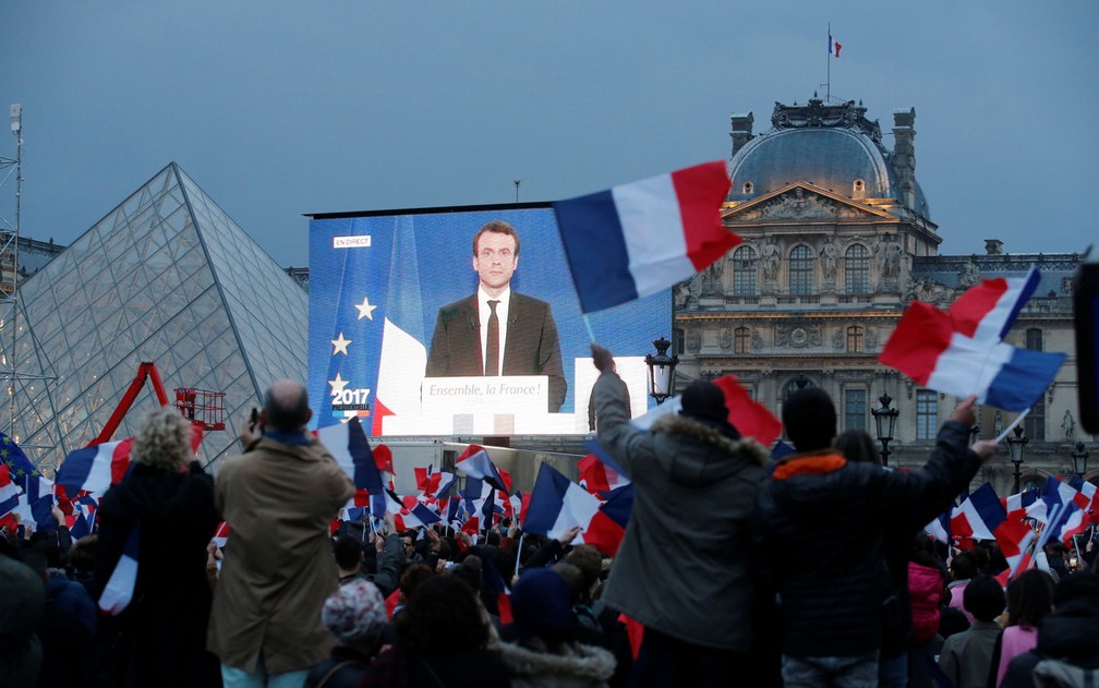 Macron é visto em telão montado próximo ao Museu do Louvre momentos após a divulgação do resultado das eleições (Foto: Jean-Paul Pelissier/Reuters)