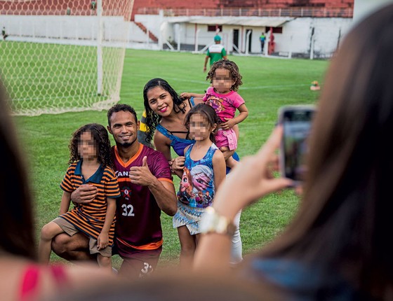 Bruno posa para fotos com crianças.Ele age como idolo apesar de poder voltar para cadeia (Foto: Adriano Vizoni/Folhapress)