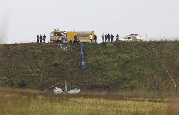 Equipes observam destroços de avião acidentado próximo ao aeroporto de Lansaria, na África do Sul, nesta segunda-feira (3) (Foto: Siphiwe Sibeko/Reuters)