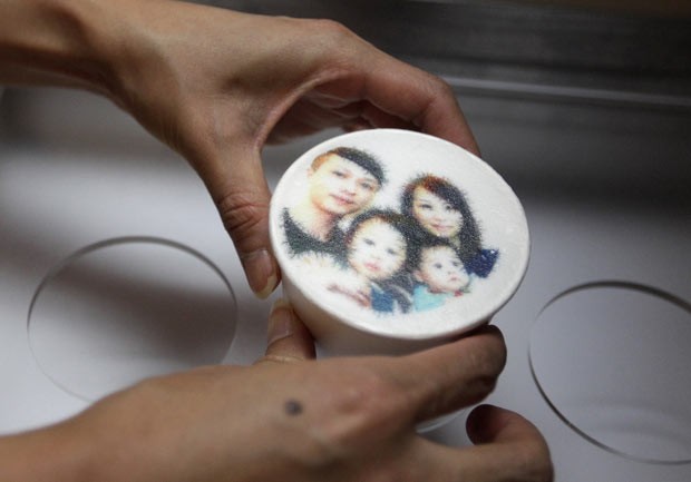 Funcionário segura latte com imagem de família em café em Taipei (Foto: Pichi Chuang/Reuters)