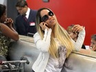 Mulher Melão faz pose ao ver o paparazzo no aeroporto
