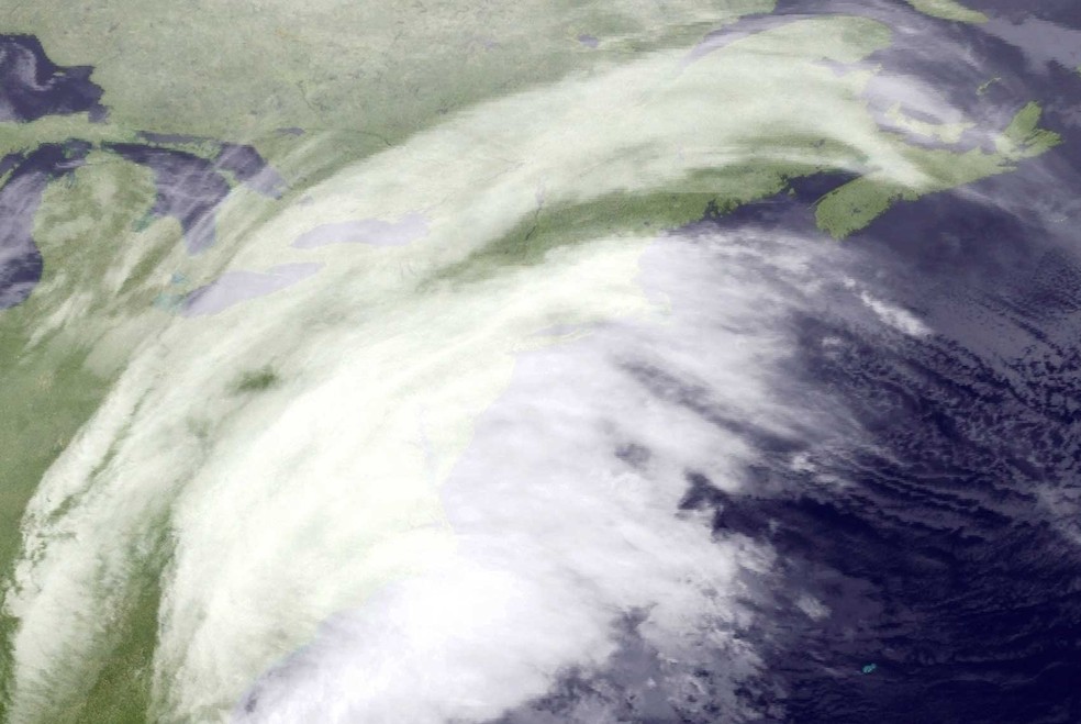Imagem de satélite divulgada pela Administração Nacional Oceânica e Atmosférica mostra nuvens no nordeste dos Estados Unidos. A região deve ser atingida por forte tempestade de neve nesta terça-feira (14)  (Foto: NOAA via AP)