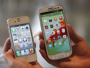 Usuário compara o iPhone 4S, da Apple, com o Galaxy S III, da Samsung (Foto: Lee Jae-Won/Reuters)