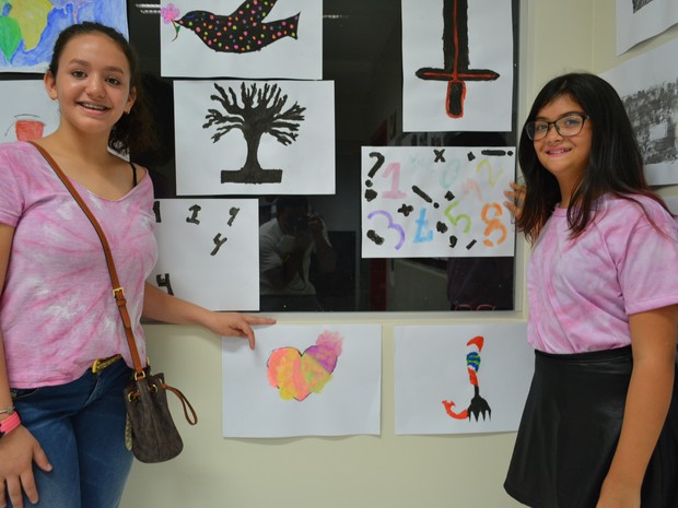 As amigas Carmen Denise e Letícia Albuquerque, do oitavo ano, ao lado das pinturas que fizeram (Foto: Toni Francis/G1)