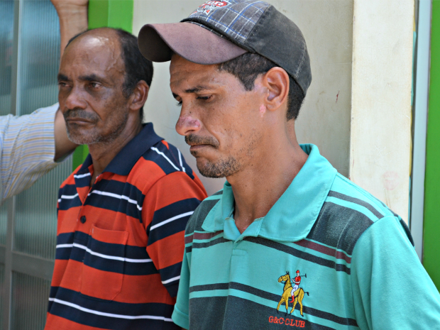 O pai (esq.) e o cunhado (dir.) aguardam a saída do suspeito para a delegacia do Bujari (Foto: Aline Nascimento/G1)