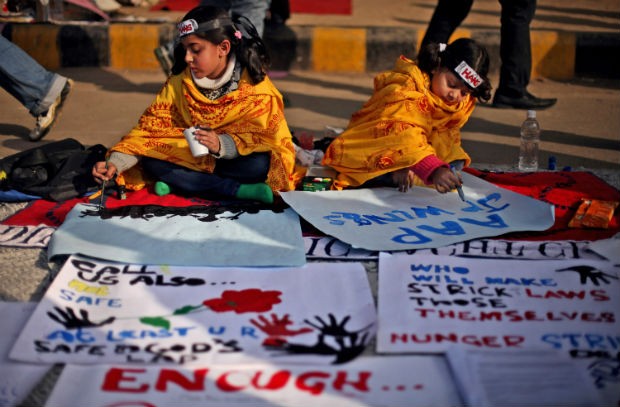 Crianças escrevem frases em homanegam à estudante Jyoti Singh Pandey, estuprada e morta por seis homens dentro de um ônibus em Nova Délhi (Foto: Altaf Qadri/AP)