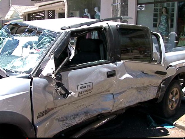 Com a força da colisão, caminhonete capotou várias vezes até atingir uma loja de roupas; passageiros ficaram presos às ferragens (Foto: Reprodução / RPC TV)