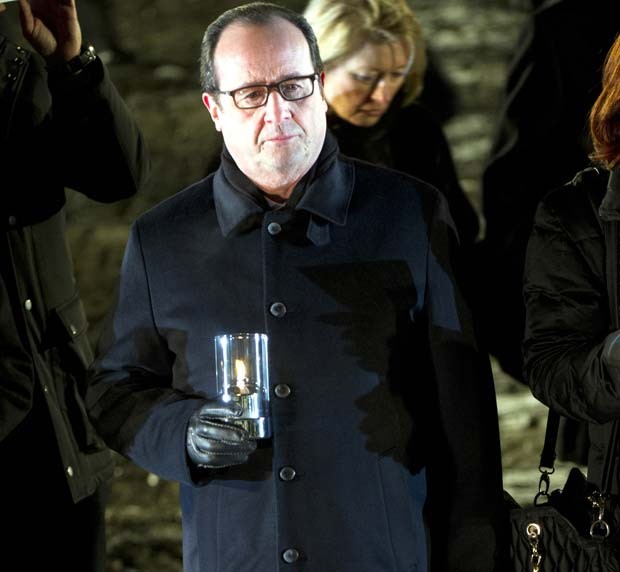 O presidente francês Francois Hollande acende vela em memória às vítimas de Auschwitz nesta terça-feira, 70 anos após a libertação do campo de concentração (Foto: AFP PHOTO / ALAIN JOCARD)