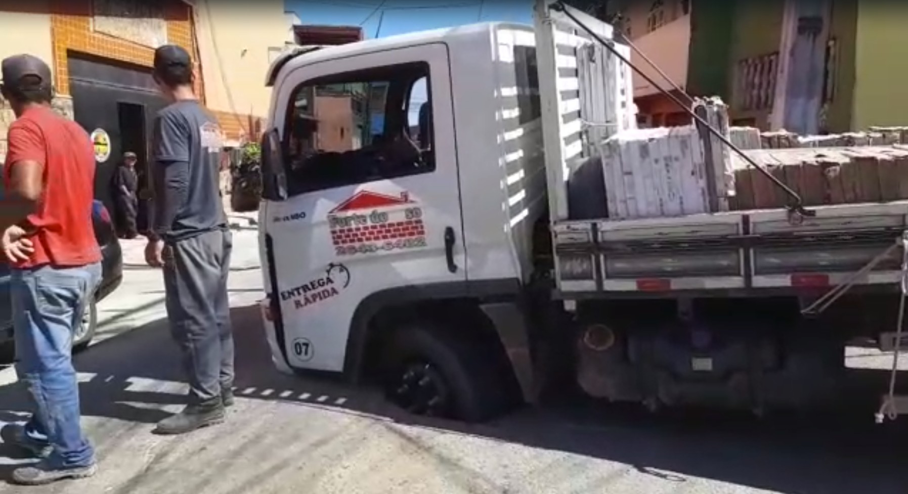 Roda de caminhão afunda em buraco no meio da rua no bairro Jacaré em