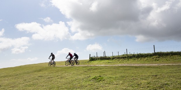 "Three mountain cyclists almost silhouetted on a ridge of a hill in the South Downs, England, UK while cycling the South West Way" (Foto: Getty Images/iStockphoto)