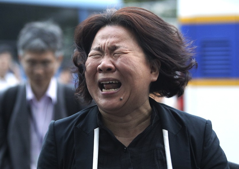 Mãe de uma das mais de 300 vítimas da balsa que naufragou em abril na Coreia do Sul chora do lado de fora do tribunal onde começou, nesta terça-feira (10), o julgamento da tripulação
