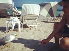 Em Miami com Mariana Rios, Di Ferrero tenta alimentar ave em praia