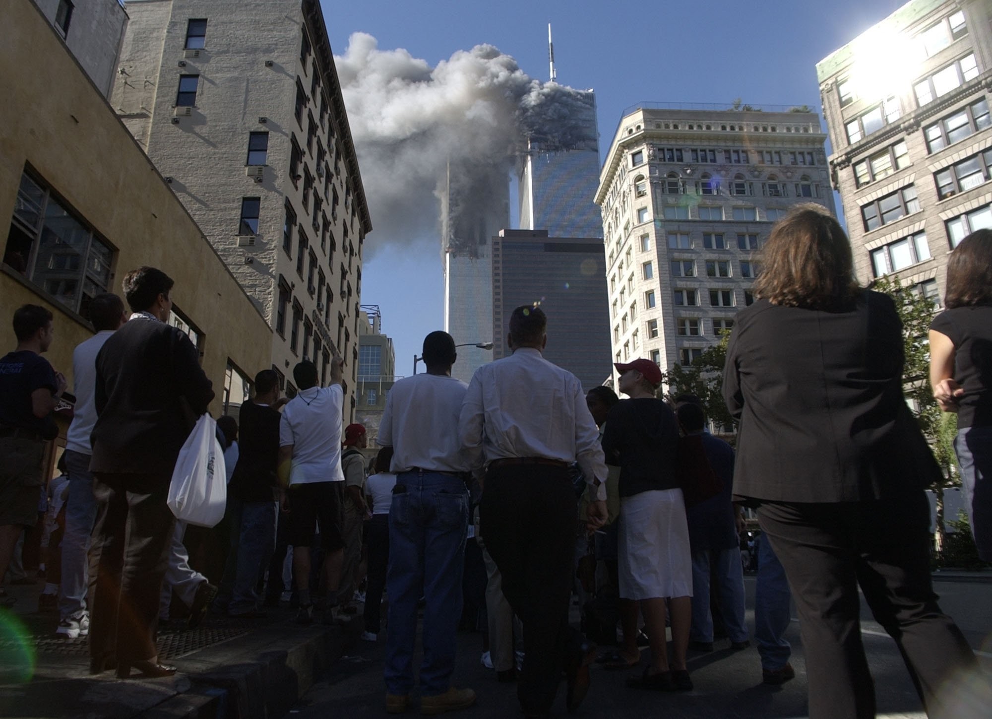 Pedestres observam as torres do World Trade Center logo após ataque