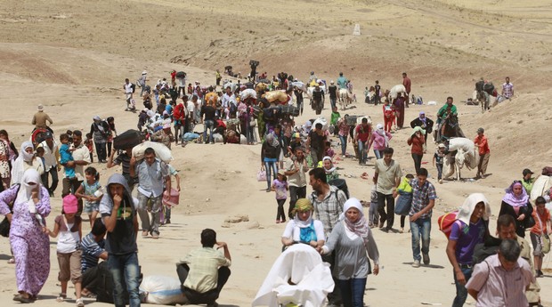 Sírios atravessam a fronteira de Peshkhabour, em Dahuk, Iraque (Foto: AP Photo/Hadi Mizban)