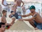 Rodrigo Hilbert brinca na areia da praia com os filhos no Rio