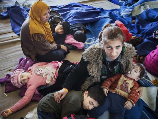 Síria acomoda seus filhos depois de serem resgatados de um barco de pesca que levava 219 pessoas que tentavam entrar na Europa (Foto: UNHCR / A. D'Amato)