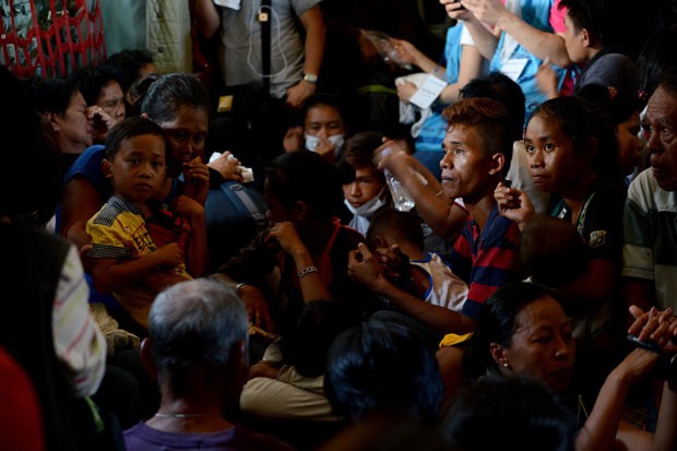  Sobreviventes do supertufão deixam Tacloban rumo a Manila, a bordo de avião militar, nesta sexta-feira (29) (Foto: AFP)