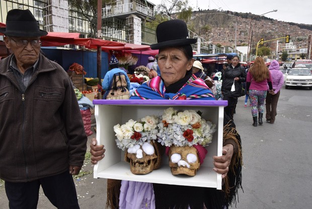  Indígena aimara chega a cerimônia em cemitério de La Paz, neste domingo (8) carregando caixa com dois crânios humanos  (Foto: AFP Photo/Aizar Raldes)