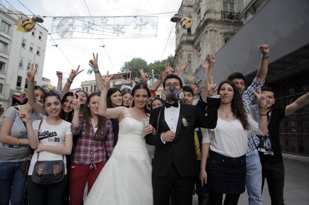 Casal turco posa para foto no domingo (2) ao lado de manifestantes em Istambul (Foto: Gurcan Ozturk/AFP)